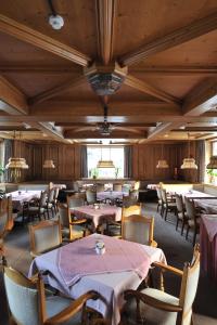 Salzburgerhof Jugend- und Familienhotel في لوفر: غرفة طعام بها طاولات وكراسي وسقف