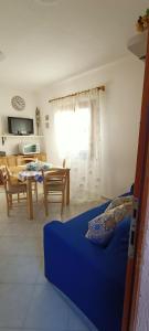 a living room with a blue couch and a table at Tanca della Torre Trilocale vista mare in Isola Rossa