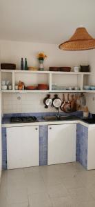 a kitchen with white cabinets and blue tiled counters at La casita in Capo Vaticano