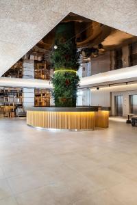 a large lobby with large plants on the ceiling at The Patio Suite Hotel in Albufeira +37 photos