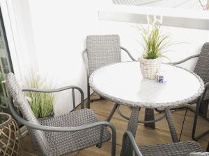 a table and chairs on a porch with plants at Küstenkind in Timmendorfer Strand