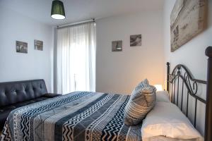 una camera da letto con un letto coperto di La Luz del Falla Ha Apartment a Cadice
