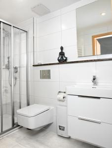 a white bathroom with a toilet and a shower at Lütt Kajüt - FIP Park in Insel Poel