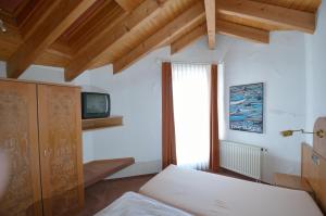 a bedroom with a bed and a tv and a window at Boarding House Remstal in Weitmars