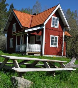 una casa rossa con un tavolo da picnic di fronte di Brännkärrstorpet B&B a Knivsta