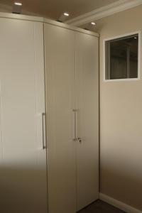 einen weißen Kleiderschrank in einem Zimmer mit Fenster in der Unterkunft Sylt-Traum Meerblick in Westerland