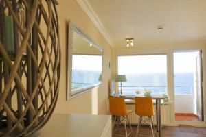 a dining room with a table and two windows at Sylt-Traum Meerblick in Westerland (Sylt)