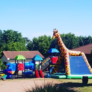 a playground with a giraffe on a slide at Camping La Grappe Fleurie in Fleurie