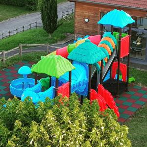 een speeltuin met een waterglijbaan met parasols bij Camping La Grappe Fleurie in Fleurie
