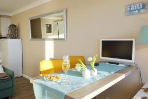 ein Wohnzimmer mit einem Tisch und einem TV in der Unterkunft Sylt-Traum Meerblick in Westerland