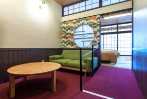 渋川市にあるいかほ秀水園の緑のソファとテーブルが備わるお部屋