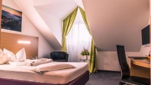 una camera da letto con un letto, una scrivania e una finestra di Arberland Tagungshaus a Regen