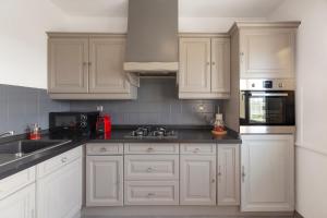 a kitchen with white cabinets and black counter tops at Travel Homes - Le Rebberg, Superbe vue à Mulhouse in Mulhouse