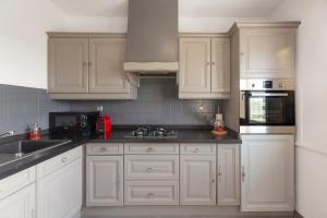 a kitchen with white cabinets and black counter tops at Travel Homes - Le Rebberg, Superbe vue à Mulhouse in Mulhouse +10 photos