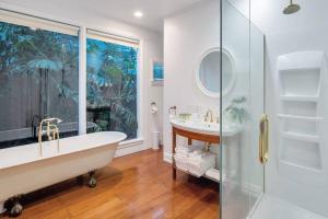 a bathroom with a tub and a glass shower at Classic Villa Retreat - Steps To Ponsonby Rd in Auckland +41 photos