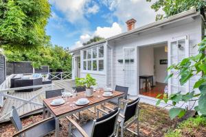 a patio with a wooden table and chairs at Classic Villa Retreat - Steps To Ponsonby Rd in Auckland