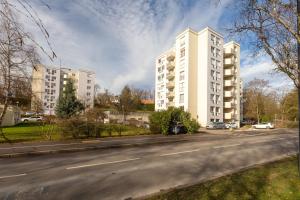 une rue vide avec deux grands bâtiments blancs dans l'établissement Travel Homes - Le Rebberg, Superbe vue à Mulhouse, à Mulhouse