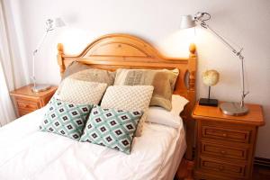 a bed with two lamps and pillows on it at Piso en Lekeitio, Costa Vasca, Bizkaia. in Lekeitio