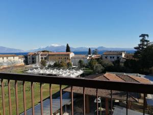 a view of a town from a balcony with tables and chairs at Guido's Apartment Villa Romana in Desenzano del Garda