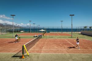 three people playing tennis on a tennis court at ROBINSON Ierapetra in Koutsounari