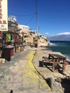 a picnic table on the side of the ocean at Fantastic Matala 1 in Matala