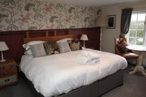 a bedroom with a large bed with towels on it at The Countryman Inn in Wool
