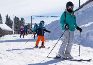 eine Gruppe von Personen, die auf einer schneebedeckten Piste Ski fahren in der Unterkunft Maison de Montagne Bretaye in Villars-sur-Ollon