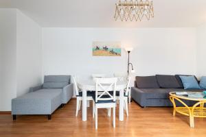 ein Wohnzimmer mit einem Sofa und einem Tisch in der Unterkunft Victus Apartamenty, Apartament Mewi Śpiew in Sopot