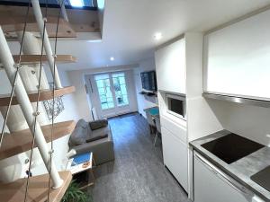a small living room with a couch and a kitchen at L'IDEAL 9 (hypercentre avec terrasse) in Deauville