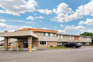 a building with a car parked in a parking lot at Quality Inn Madison West Near University Area in Madison