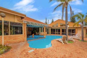 a house with a swimming pool in front of a house at Comfort Inn Bay of Isles in Esperance