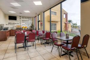 a waiting room with tables and chairs in a restaurant at Econo Lodge Inn & Suites Maingate Central in Kissimmee