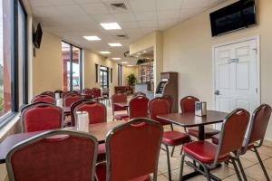 ein Esszimmer mit Tischen und roten Stühlen in der Unterkunft Econo Lodge Inn & Suites Maingate Central in Kissimmee