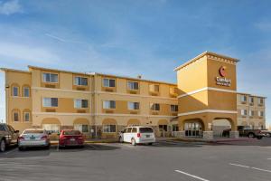 un gran edificio amarillo con coches aparcados en un aparcamiento en Comfort Inn & Suites Alameda at Albuquerque Balloon Fiesta Park, en Albuquerque