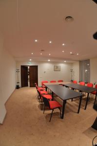 einen Konferenzraum mit Tischen und roten Stühlen in der Unterkunft Coroana Brasovului in Braşov