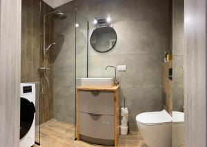 a bathroom with a sink and a toilet and a mirror at Apartamenty u Rybki in Krynica Zdrój