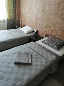 a bedroom with two beds and a table with a towel at Apartment by the park in Imatra