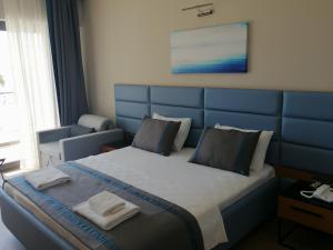 a bedroom with a blue bed with two towels on it at Doğruer Hotel & Spa in Muğla +23 photos