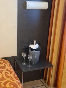 uma mesa com dois copos de vinho e um balde em Elysium Hotel Raya em Mediglia