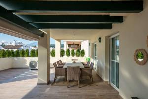 une salle à manger avec une table et des chaises sur une terrasse dans l'établissement STUNNING APARTMENT NEXT TO PUERTO BANUS, à Marbella