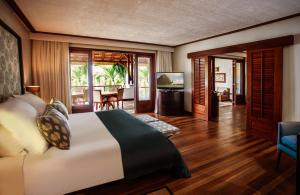 a bedroom with a bed and a living room at Paradis Beachcomber Golf Resort & Spa in Le Morne