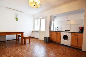 Work and Stay Apartment in Troisdorf في ترويسدورف: مطبخ مع طاولة وغسالة ملابس