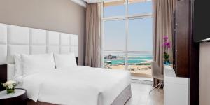 A bed or beds in a room at Staybridge Suites - Doha Lusail by IHG