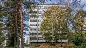 een wit gebouw met bomen ervoor bij Cozy studio with Spectacular view Just near Nature and the Sea in Helsinki