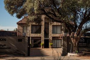 a building with a tree in front of it at Silverton Travel Lodge in Pretoria