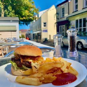 a plate with a sandwich and french fries on a table at La Ville Hotel in Alderney