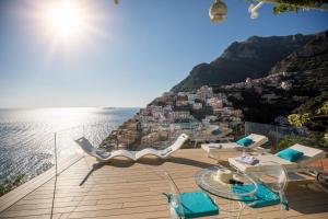 uma varanda com cadeiras e vista para o oceano em Villa Fiorentino em Positano