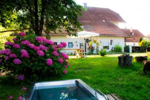 a house with a bush of purple flowers in a yard at Taverne Vachenlueg in Anger