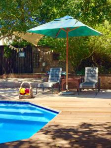 a blue umbrella and two chairs and a swimming pool at Darling Lodge Guest House in Darling