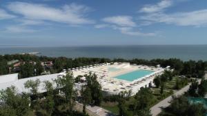eine Luftaufnahme eines Resorts mit Swimmingpool in der Unterkunft Happy Camp Mobile Homes in Camping Village Rosapineta in Rosolina Mare
